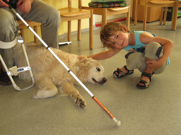 Das Bild zeigt ein Kind mit dem Blindenführhund Benny